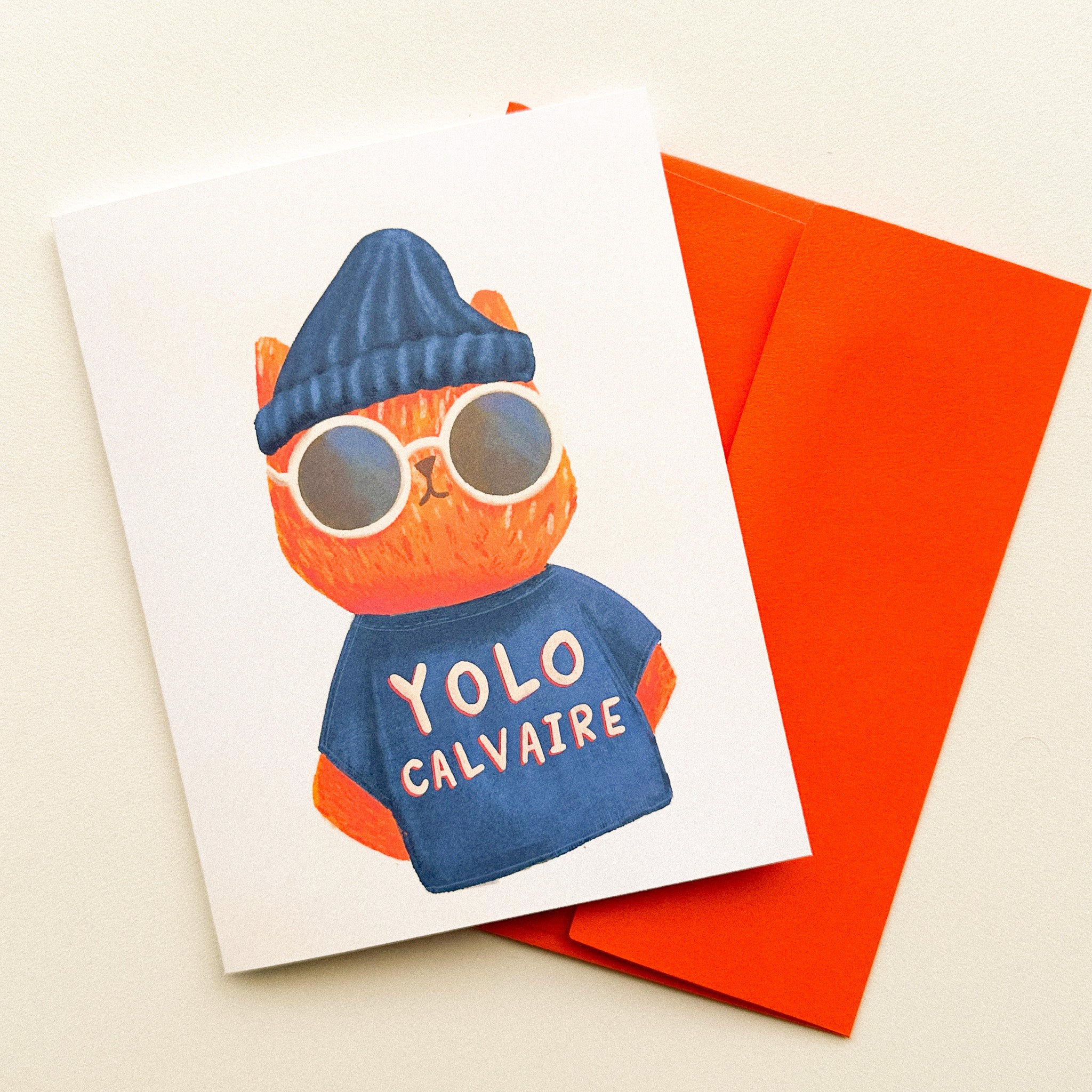 Illustration d'un chat cool portant un t-shirt avec l'inscription Yolo Calvaire sur une carte de voeux humoristique